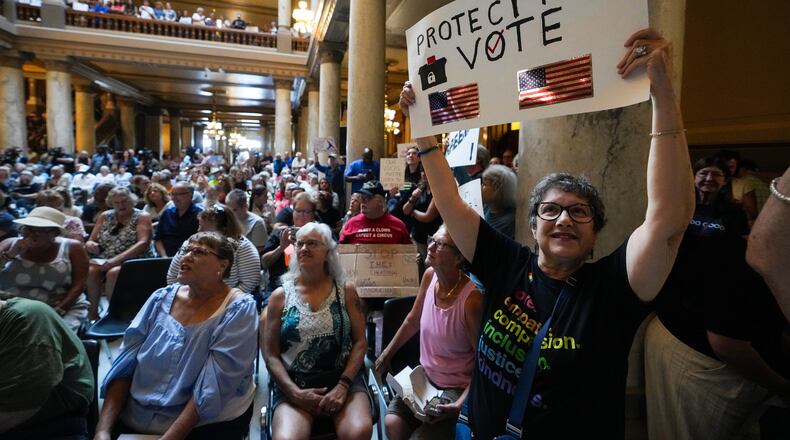 FILE - Annette Groos holds a sign before the start of a rally featuring former Transportation Secretary Pete Buttigieg at the Statehouse in Indianapolis, Thursday, Sept. 18, 2025 for Indiana Democrats amid pressure from President Donald Trump on Republicans who control the state's legislature to redistrict congressional seats. (AP Photo/Michael Conroy, File)