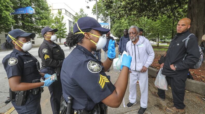 In an April 2020 file photo, Atlanta police officer Brittany Searight, Sgt. Sabrina Smith and Sgt. Dominique Simmons distribute masks at Hurt Park in downtown Atlanta. JOHN SPINK/SPINK@AJC.COM