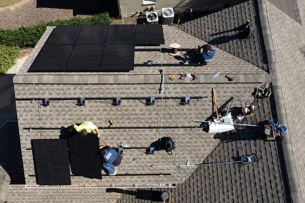 Workers with Creative Solar USA install solar panels on Nathan Shaffer’s roof on Friday, Oct. 24, 2025, in Decatur. With $6,000 to $7,000 in potential savings set to vanish next year, Shaffer decided to install new panels before the credits expired. (Ben Gray for the AJC)