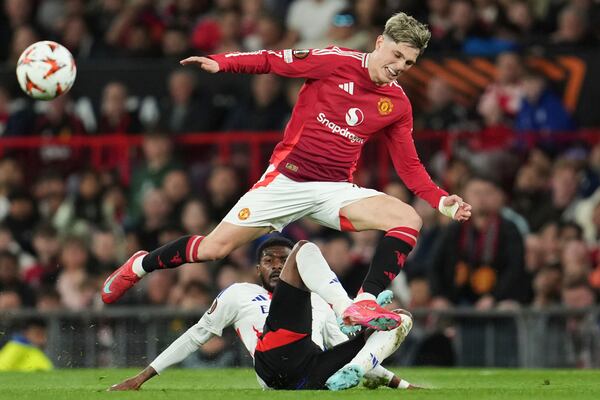 Manchester United's Alejandro Garnacho, top, and Lyon's Ainsley Maitland-Niles challenge for the ball during the Europa League quarter final second leg soccer match between Manchester United and Olympique Lyon in Manchester, Britain, Thursday, April 17, 2025. (AP Photo/Jon Super)