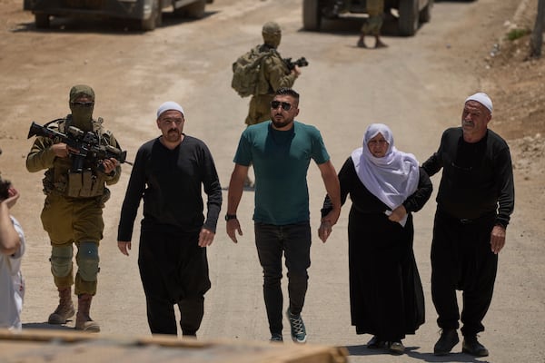 Syrian Druze people cross back into Syria as they walk at the Israeli-Syrian border, in the Israeli-controlled Golan Heights town of Majdal Shams, Thursday, July 17, 2025. (AP Photo/Leo Correa)