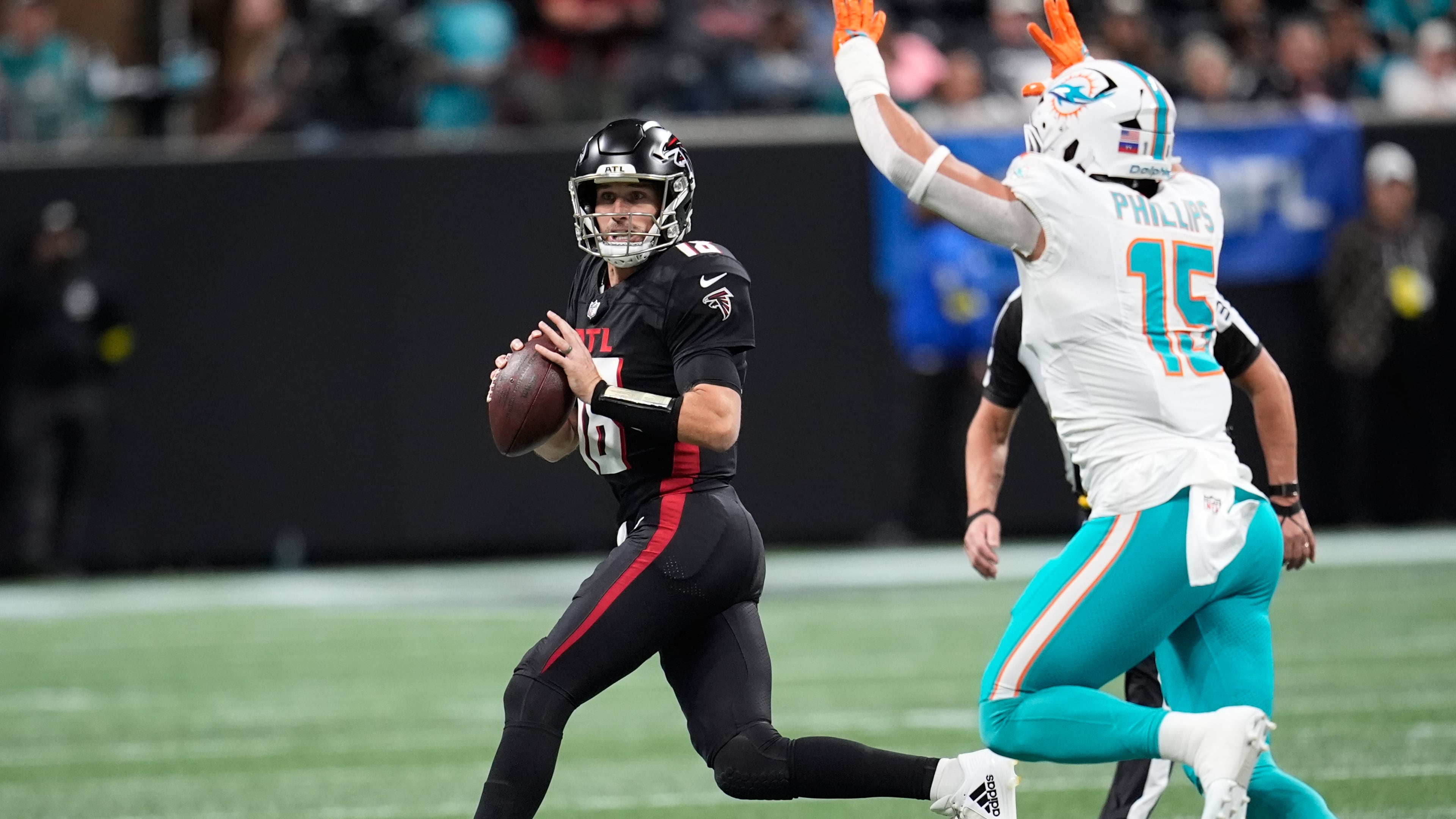 Atlanta Falcons quarterback Kirk Cousins (18) looks to pass as Miami Dolphins linebacker Jaelan Phillips (15) defends during the first half of an NFL football game Sunday, Oct. 26, 2025, in Atlanta. (AP Photo/Mike Stewart)