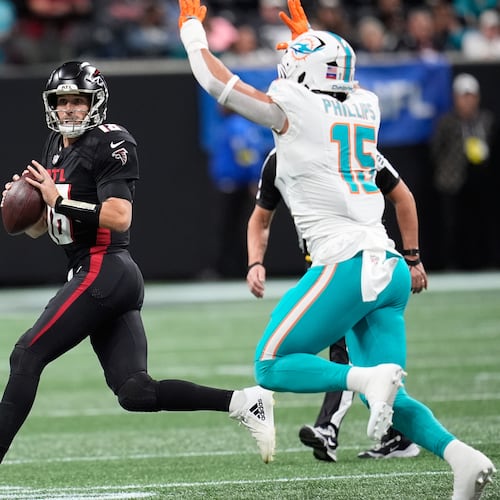 Atlanta Falcons quarterback Kirk Cousins (18) looks to pass as Miami Dolphins linebacker Jaelan Phillips (15) defends during the first half of an NFL football game Sunday, Oct. 26, 2025, in Atlanta. (AP Photo/Mike Stewart)