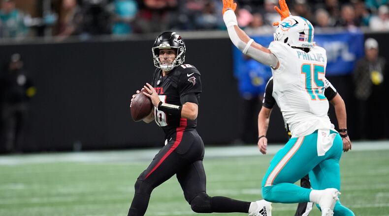 Atlanta Falcons quarterback Kirk Cousins (18) looks to pass as Miami Dolphins linebacker Jaelan Phillips (15) defends during the first half of an NFL football game Sunday, Oct. 26, 2025, in Atlanta. (AP Photo/Mike Stewart)