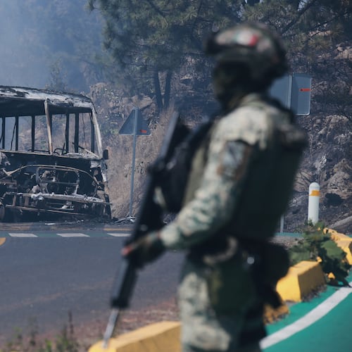 FILE - A soldier stands guard by a charred vehicle after it was set on fire in Cointzio, Michoacán state, Mexico, Feb. 22, 2026, following the death of the leader of the Jalisco New Generation Cartel, Nemesio Oseguera, also known as "El Mencho." (AP Photo/Armando Solis, File)