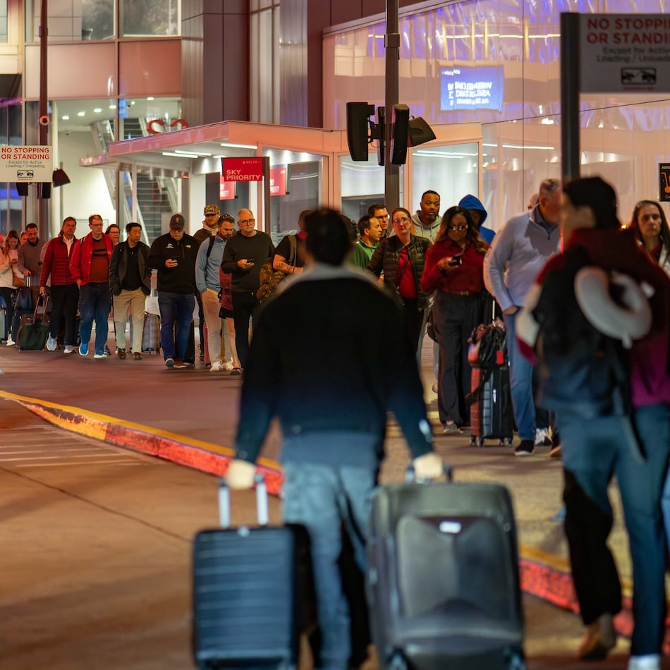 Before sunrise Wednesday, travelers wait in lines stretching to the sidewalk at Hartsfield-Jackson Atlanta International Airport amid the ongoing partial government shutdown. A little after 7 a.m., the outside line had receded. (Ben Hendren for the AJC)