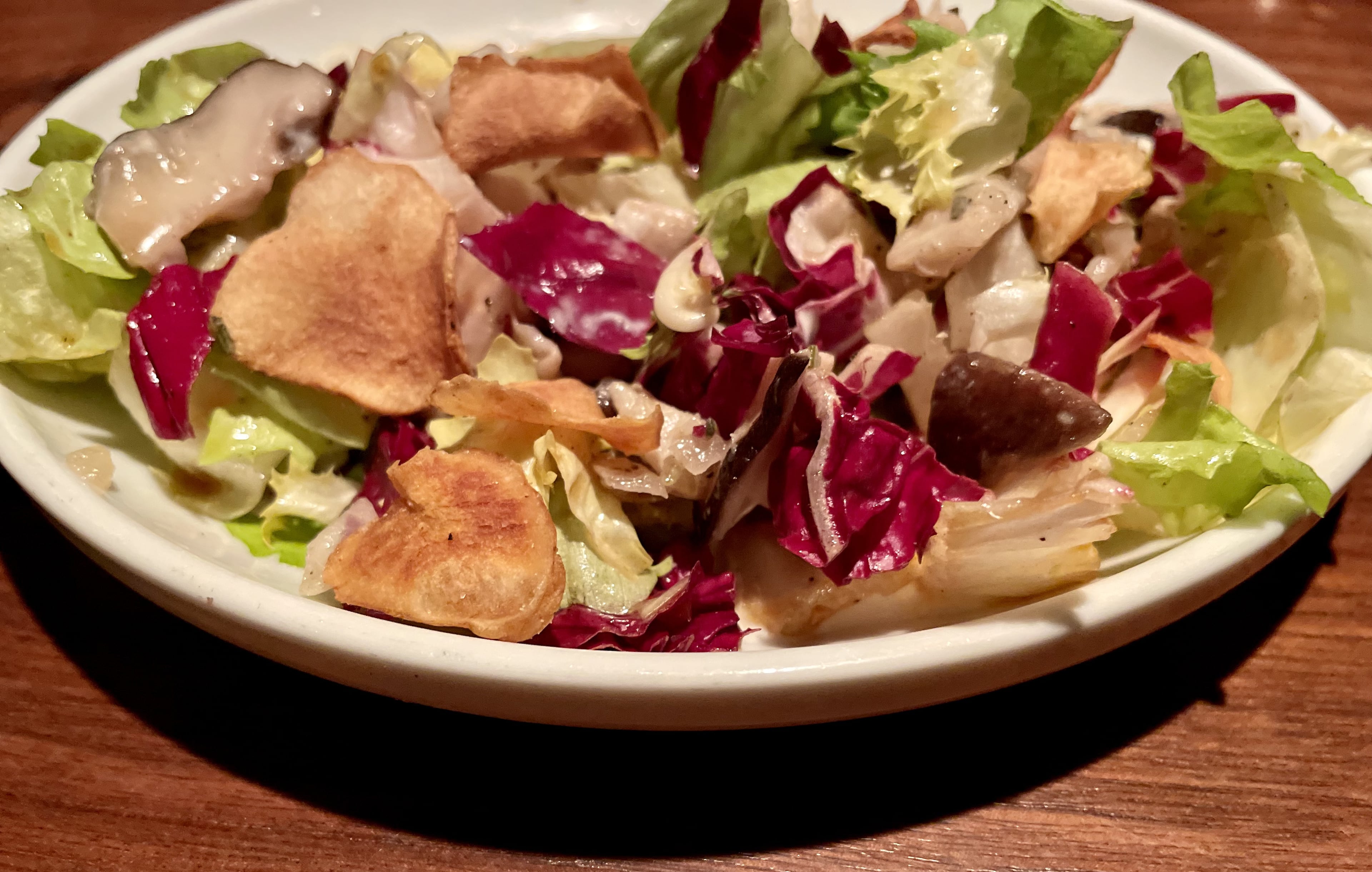 Marinated mushrooms with escarole, crispy sunchokes and goat cheese from BoccaLupo. (Angela Hansberger for the AJC)