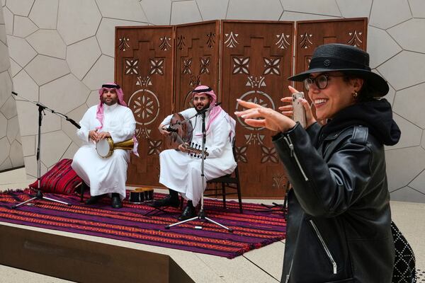 A visitor dances to music performed at Saudi Arabia's pavilion during the Expo 2025 in Osaka, western Japan, Tuesday, April 15, 2025. (AP Photo/Hiro Komae)
