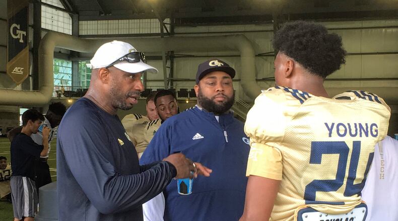 Georgia Tech defensive ends/outside linebackers coach Marco Coleman (left, in white cap) speaks with freshman defensive end Kendall Young with defensive analyst Anthony Parker looking on during a break in preseason practice August 2, 2019. (AJC photo by Ken Sugiura)