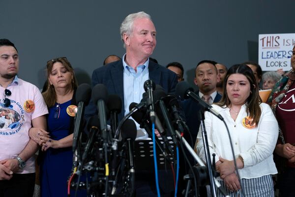 Sen. Chris Van Hollen, D-Md., center, accompanied by Cesar Abrego Garcia, from left, Cecilia Garcia and Jennifer Vasquez Sura, speaks during a news conference upon his arrival from El Salvador at Washington Dulles International Airport, in Chantilly, Va., Friday, April 18, 2025, in Washington. (AP Photo/Jose Luis Magana)