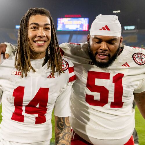 Nebraska quarterback TJ Lateef (14) and Nebraska offensive lineman Justin Evans (51) embrace after defeating UCLA at an NCAA college football game Saturday, Nov. 8, 2025, in Pasadena, Calif. (AP Photo/Ethan Swope)
