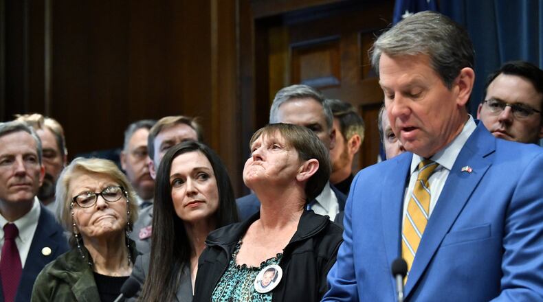 Gov. Brian Kemp introduces anti-gang bills as Deborah Rider (center), who lost her son in a drive-by shooting, tries to hold her tears during a press conference at the Georgia State Capitol building in Atlanta on Thursday, January 30, 2020. (Hyosub Shin / Hyosub.Shin@ajc.com)