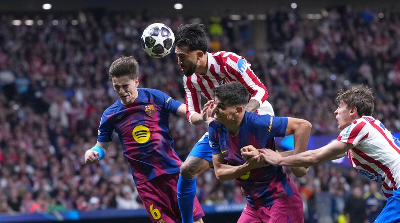 Atletico Madrid's Nicolas Gonzalez, top, heads the ball during the Champions League quarterfinal second leg soccer match between Atletico Madrid and Barcelona in Madrid, Spain, Tuesday, April 14, 2026. (AP Photo/Manu Fernandez)