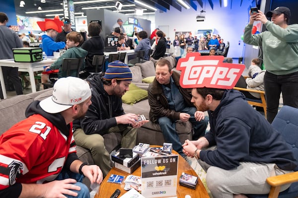 Avi Ghlzadeh (second from left) attracts a lot of attention as he rifles through a just-opened box of Panini Noir NBA trading cards.