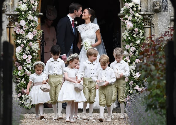 Pippa Middleton, background right, kisses James Matthews after their wedding at St Mark's Church in Englefield, England, Saturday, May 20, 2017. Middleton, the sister of Kate, Duchess of Cambridge married hedge fund manager James Matthews in a ceremony Saturday where her niece and nephew Prince George and Princess Charlotte was in the wedding party, along with sister Kate and princes Harry and William. (Justin Tallis/Pool Photo via AP)