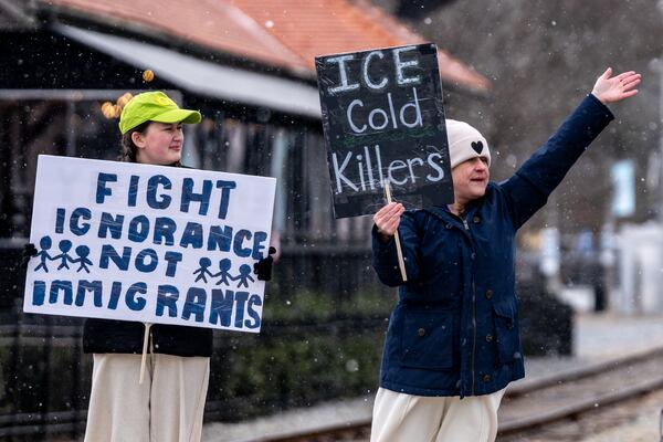 Caroline Campbell (left) and Erin Campbell (right) protest Immigration and Customs Enforcement in downtown Woodstock, Georgia. Saturday, Jan 31, 2026. (Ben Hendren for the AJC)