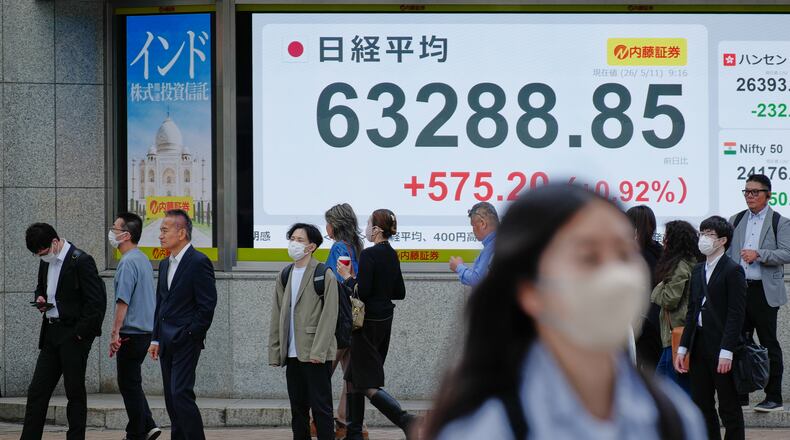 People stand in front of an electronic stock board showing Japan's Nikkei index at a securities firm Monday, May 11, 2026, in Tokyo. (AP Photo/Eugene Hoshiko)