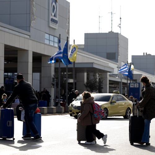 Passengers make their way to Athens' Eleftherios Venizelos international airport in Athens, Greece, Sunday, Jan. 4, 2026, as many flights were disrupted across Greece. (AP Photo/Yorgos Karahalis)