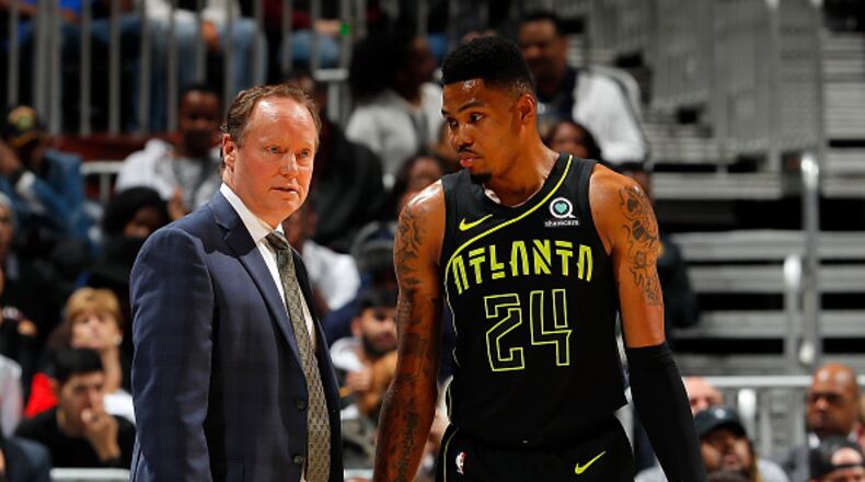 Hawks coach Mike Budenholzer discusses a no doubt difficult situation with Kent Bazemore. (Kevin C. Cox/Getty Images)