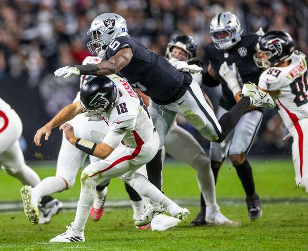 Atlanta Falcons quarterback Kirk Cousins (18) is taken down after a rushed pass by Las Vegas Raiders linebacker Divine Deablo (5) during the first half of their NFL game at Allegiant Stadium on Monday, Dec. 16, 2024, in Las Vegas. (L.E. Baskow/Las Vegas Review-Journal/TNS)