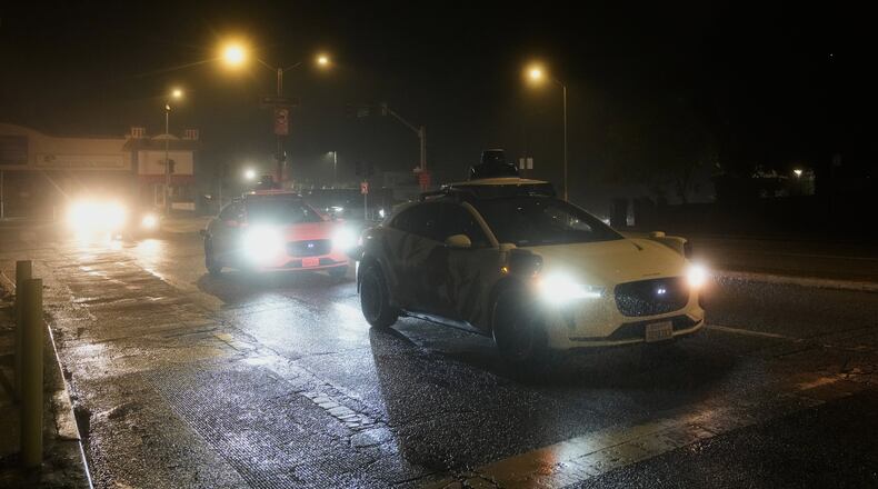 A Waymo vehicle sits idling at an intersection with no operating traffic lights due to power outages, in San Francisco, Saturday, Dec. 20, 2025. (AP Photo/Jeff Chiu)