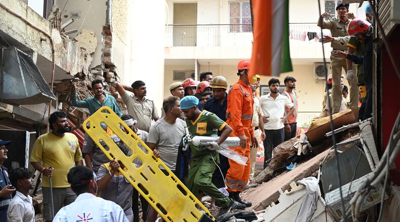 Rescue workers look for the trapped survivors under the debris of a building that collapsed in New Delhi, India, Sunday, Sept. 6, 2026. (AP Photo/ Vipin)