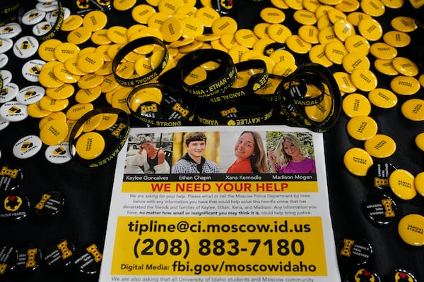FILE - A flyer seeking information about the killings of four University of Idaho students who were found dead is displayed on a table along with buttons and bracelets, on Nov. 30, 2022, during a vigil in memory of the victims in Moscow, Idaho. (AP Photo/Ted S. Warren, File)