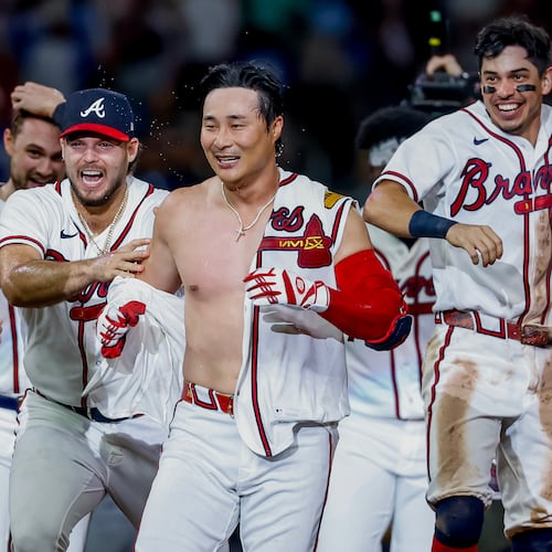 Atlanta Braves pinch-hitter Ha-Seong Kim, center, is mobbed by teammates Victor Mederos, left, and Mauricio Dubón, right, after Kim hit a game-winning RBI single against the Los Angeles Dodgers during the ninth inning of a baseball game, Wednesday, Aug. 26, 2026, in Atlanta. (AP Photo/Erik S. Lesser)