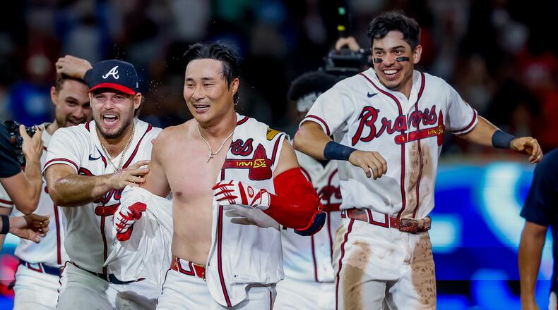 Atlanta Braves pinch-hitter Ha-Seong Kim, center, is mobbed by teammates Victor Mederos, left, and Mauricio Dubón, right, after Kim hit a game-winning RBI single against the Los Angeles Dodgers during the ninth inning of a baseball game, Wednesday, Aug. 26, 2026, in Atlanta. (AP Photo/Erik S. Lesser)