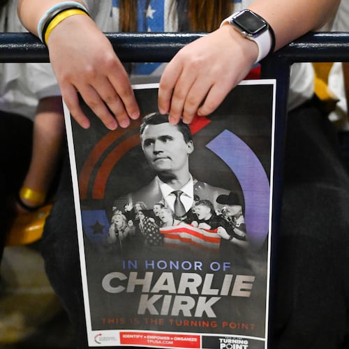FILE - An attendee holds a poster of Charlie Kirk during a Turning Point USA rally, Sept. 30, 2025, in Logan, Utah. (AP Photo/Alex Goodlett, File)