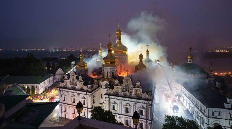 Rescue workers try to put out a fire at the Dormition Cathedral of thousand-year-old Monastery of Caves, also known as Kyiv Pechersk Lavra, following a Russian strike on Kyiv, Ukraine, Monday, June 15, 2026. (AP Photo/Evgeniy Maloletka)