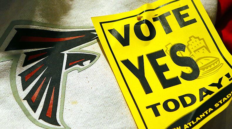 031813 ATLANTA: Lena Reid-Morrow, Atlanta, wears a Falcons sweat shirt and a vote yes sign to show her support of a new Atlanta stadium before the Atlanta City Council votes on a plan to put what could be hundreds of millions of tax dollars into the project on Monday, March 18, 2013, in Atlanta. Reid-Morrow also spoke out in favor of the stadium during public comments. CURTIS COMPTON / CCOMPTON@AJC.COM