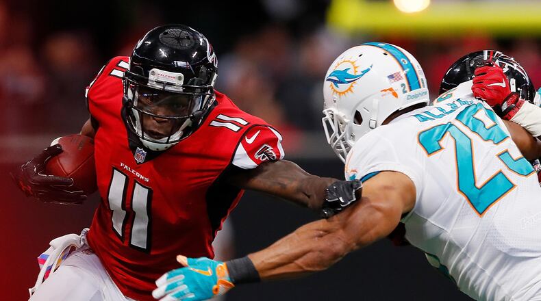 Falcons wide receiver Julio Jones stiff-arms Nate Allen of the Dolphins at Mercedes-Benz Stadium last Sunday in Atlanta.