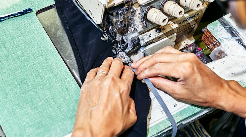 A seamstress at the New York factory E & C Fashion Design works on a swimsuit on June 2, 2022.  (An Rong Xu/The New York Times)