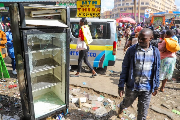 Business owners assess the damage to their vandalized merchandise and shop, following the one-year anniversary of a deadly anti-tax demonstration in Nairobi, Kenya, Thursday, June 26, 2025. (AP Photo/Patrick Ngugi)