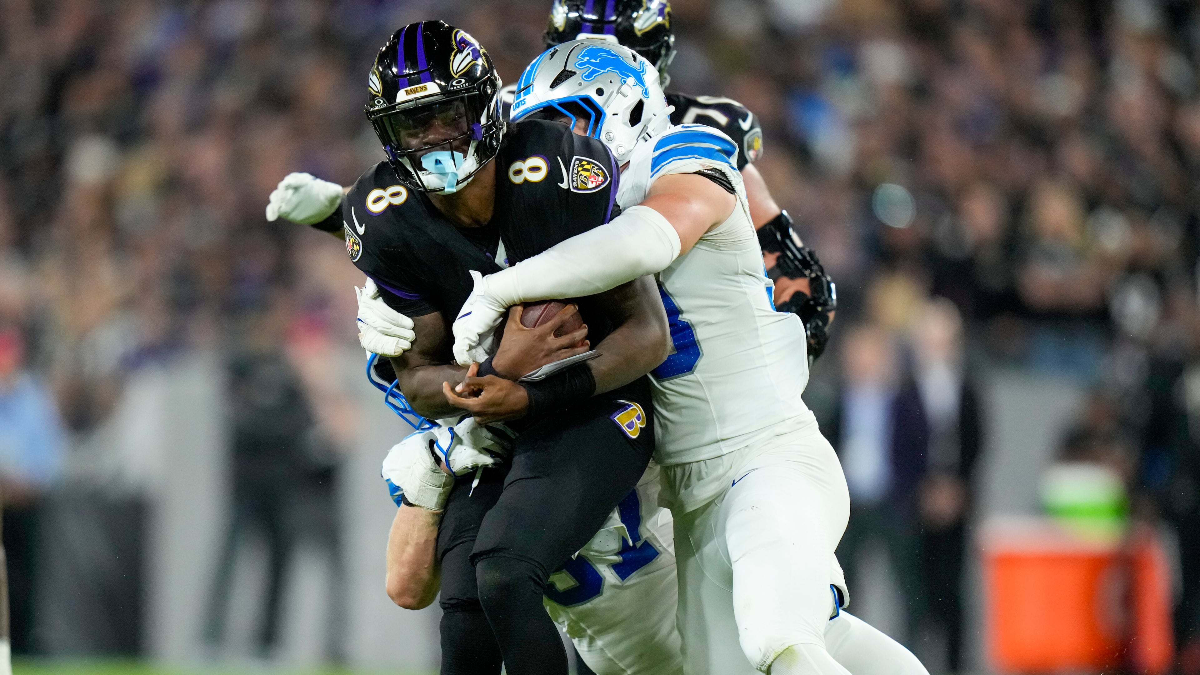 Baltimore Ravens quarterback Lamar Jackson (8) is brought down by Detroit Lions linebacker Trevor Nowaske, right, and defensive end Aidan Hutchinson, bottom, during the second half of an NFL football game Monday, Sept. 22, 2025, in Baltimore. (AP Photo/Stephanie Scarbrough)