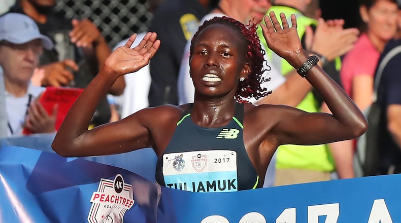Aliphine Tuliamuk hits the finish line to win the women’s division in the 48th running of the AJC Peachtree Road Race with an unofficial time of 32:49 on Tuesday, July 4, 2017, in Atlanta. Curtis Compton/ccompton@ajc.com