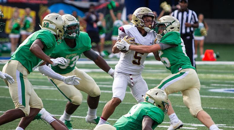 Tucker running back Tyler Hughey is tackled by Buford's Hayden Olsen during the 2018  Corky Kell Classic Friday, Aug.17, 2018, at Georgia State Stadium in Atlanta.