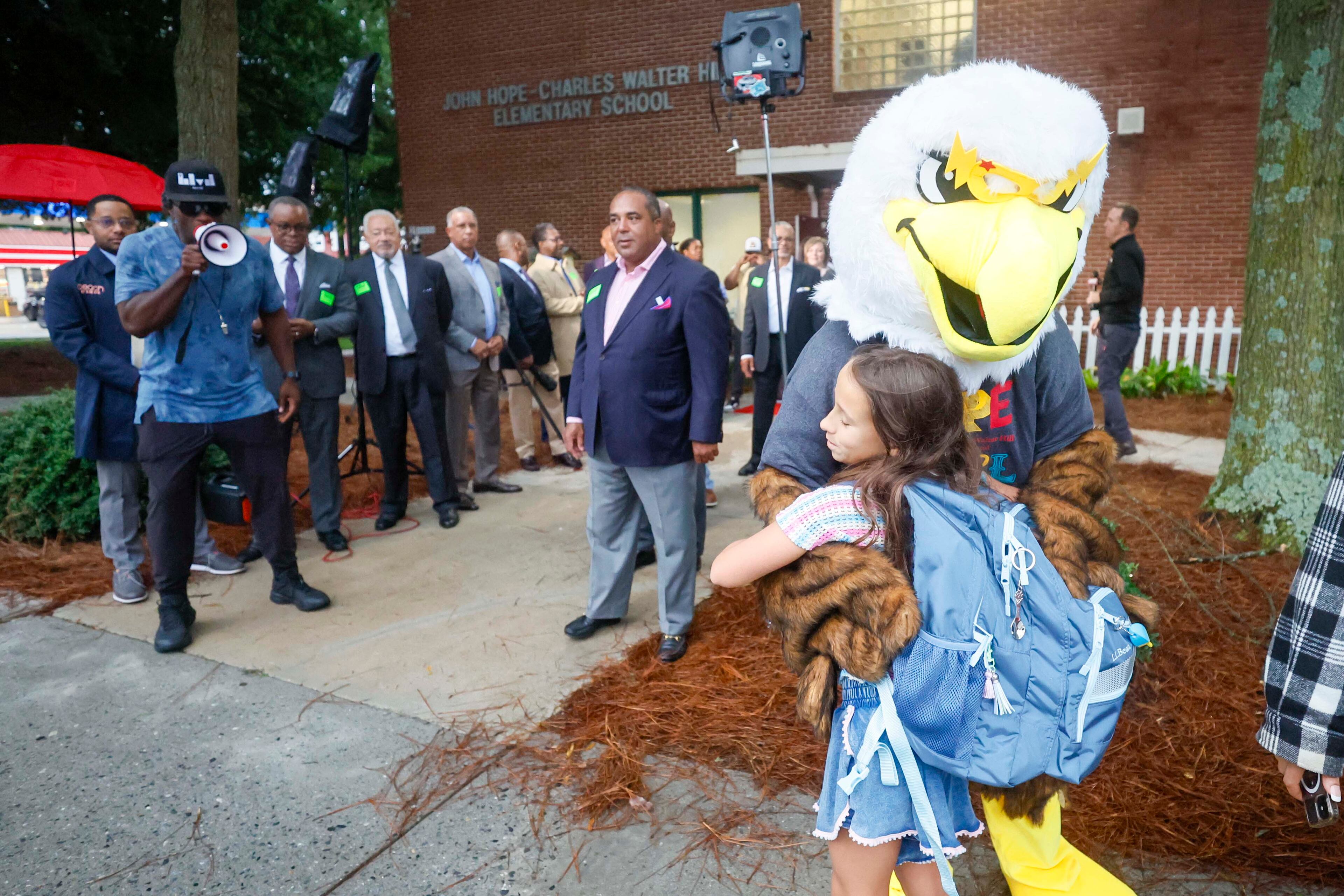 Fourth grader Emma Mostoller is welcomed by Echo the eagle during the first day of classes at Hope-Hill Elementary. (Miguel Martinez/AJC)