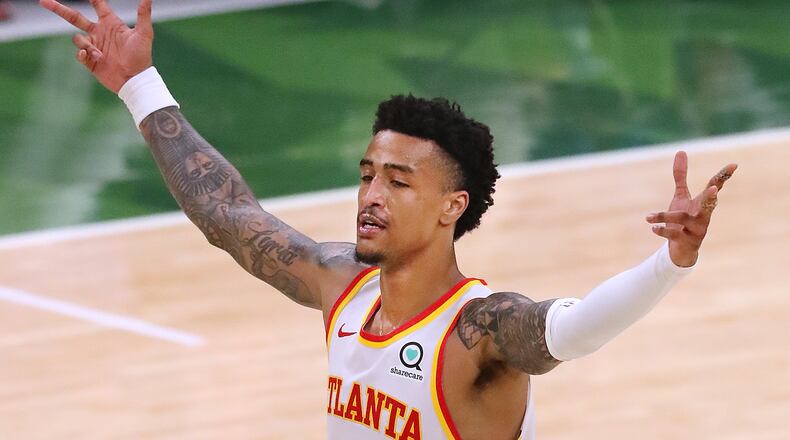 Hawks forward John Collins reacts as Trae Young hits a three pointer during a 116-113 victory over the Milwaukee Bucks in Game 1 of the Eastern Conference Finals Wednesday, June 23, 2021, in Milwaukee. (Curtis Compton / Curtis.Compton@ajc.com)