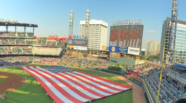 Declan Clear, a newly naturalized American citizen, helps to carry the American flag at Truist Park during a Flag Day ceremony this year.