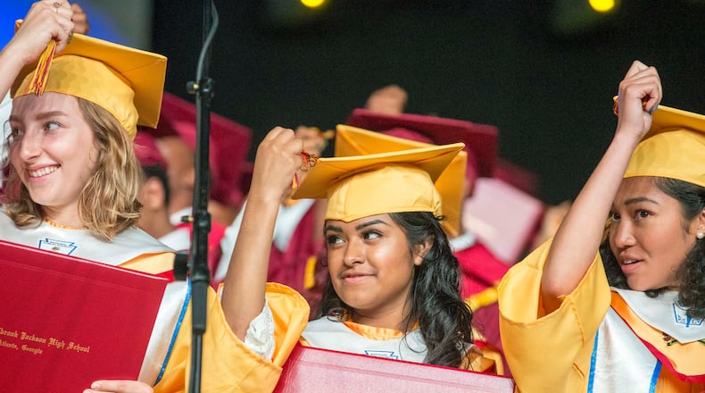 Marisela Lozada (center) and her classmates turn their tassels on their graduation cap during the commencement ceremony for Maynard Jackson High School at the Georgia World Congress Center in Atlanta on May 22, 2018. ALYSSA POINTER/ATLANTA JOURNAL-CONSTITUTION