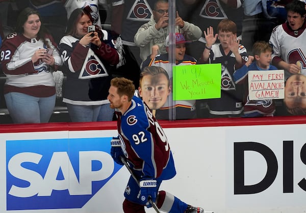 Fans cheer as Colorado Avalanche left wing Gabriel Landeskog warms up before the first period of Game 3 of an NHL first-round hockey playoff series against Dallas Wednesday, April 23, 2025, in Denver. (AP Photo/David Zalubowski)