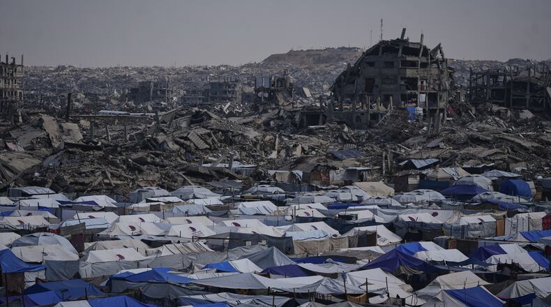 Tents sheltering displaced Palestinians stand amid the destruction left by the Israeli air and ground offensive in Gaza City Friday, Dec. 5, 2025. (AP Photo/Abdel Kareem Hana)