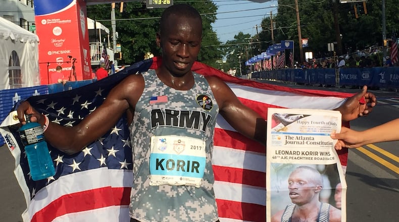 Leonard Korir holds the American flag after winning the AJC Peachtree Road Race. He posted a time of 28:16.