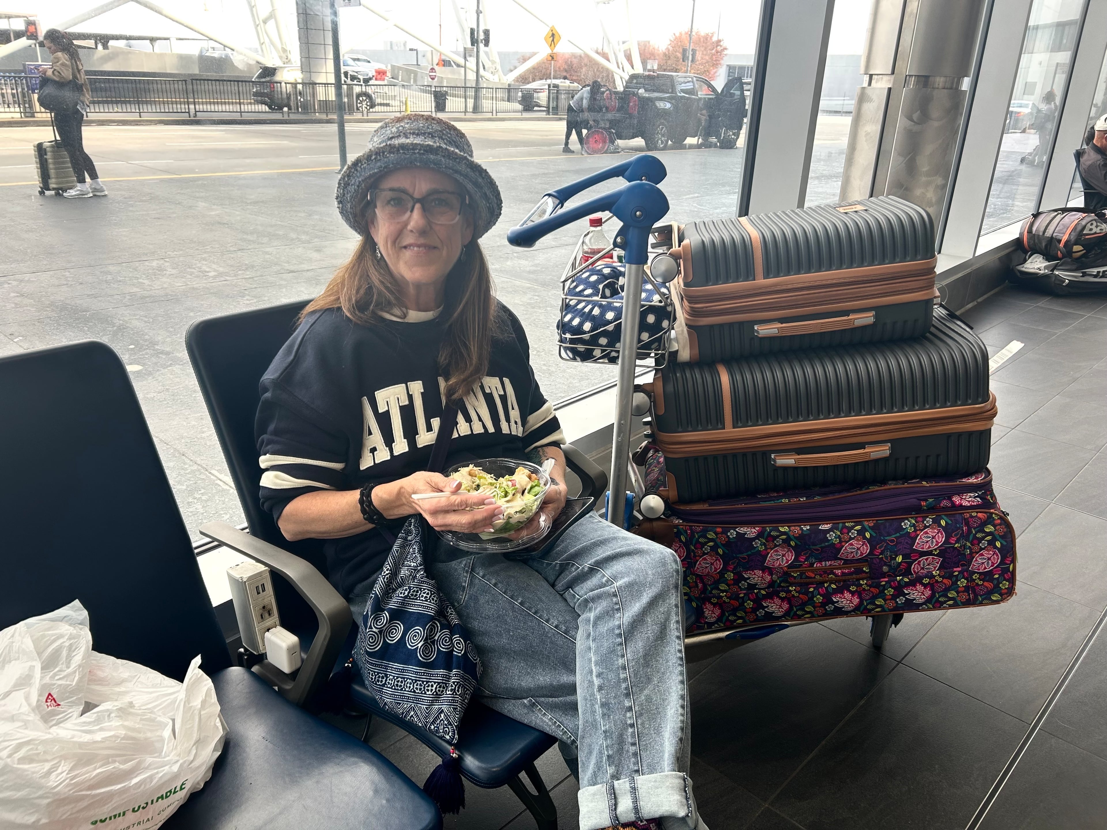 Mary Ann Van Booren sits at Hartsfield-Jackson Atlanta International Airport on Sunday, Nov. 9, 2025, while waiting to see if she'll be able to get on a 7:20 p.m. standby flight back to Boston. (Olivia Wakim/AJC)