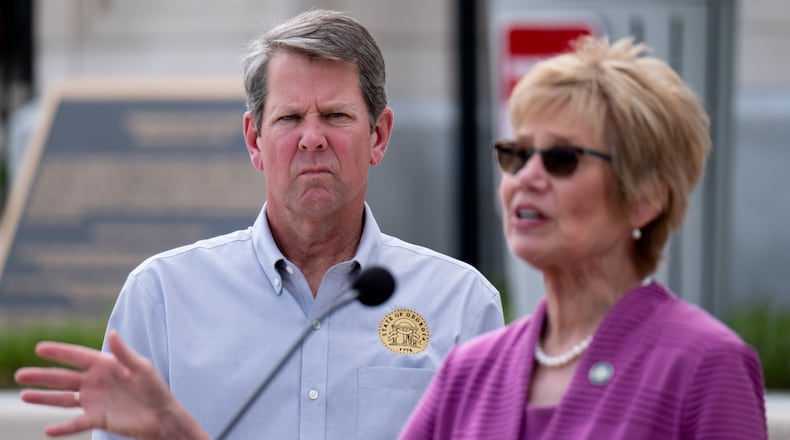 Gov. Brian Kemp listens as Kathleen Toomey, commissioner of the Georgia Department of Public Health, answers a journalist’s question during a press conference outside of the State Capitol on April 13, 2020. (Ben Gray for The Atlanta Journal-Constitution)