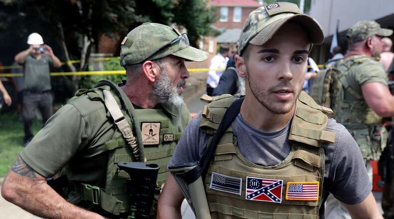 White nationalists, neo-Nazis and members of the "alt-right" with body armor and combat weapons evacuate comrades who were pepper sprayed after the "Unite the Right" rally was declared a unlawful gathering by Virginia State Police on Saturday in Charlottesville, Virginia (Photo by Chip Somodevilla / Getty Images)