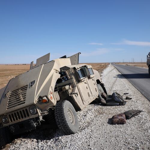 A truck drives past a damaged Humvee abandoned by retreating Syrian Democratic Forces (SDF) along a road between government-controlled Raqqa and SDF-controlled Hassakeh in northeastern Syria, Tuesday, Jan. 20, 2026. (AP Photo/Omar Albam)