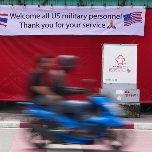 A motorcycle taxi drives past a banner in Pattaya, Thailand, Tuesday, Sept. 1, 2026. (AP Photo/Sakchai Lalit)